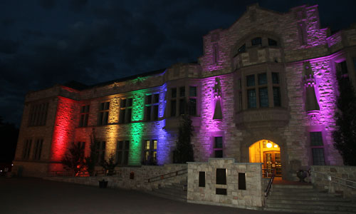 Peter MacKinnon is lit in a rainbow of coloured lights.